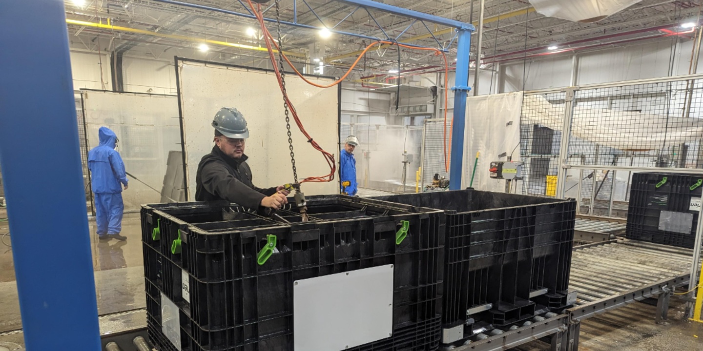 Team members un-nest a seedbox on the wash line. Separating the top ring from the base allows TriRinse to thoroughly clean the inside and outside of the seedbox. Once the parts are separated, the box travels our automated wash line and is inspected for necessary repairs.